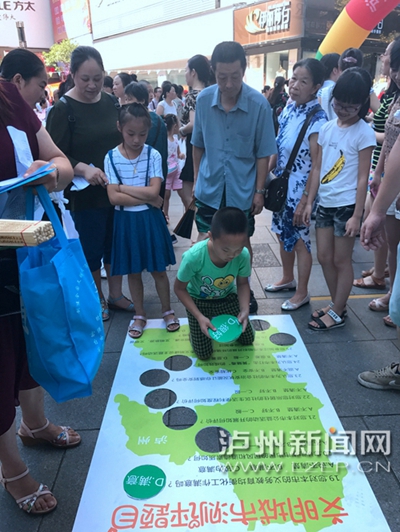 市民在宣傳點(diǎn)參加創(chuàng)文趣味游戲。 記者 朱虹 攝